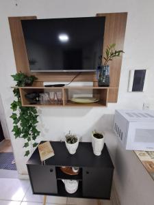 un centre de divertissement avec une télévision sur un mur dans l'établissement Condominio Merces, à Belo Horizonte