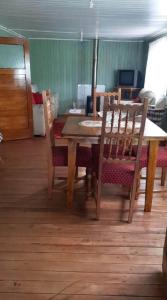 mesa de comedor con sillas y suelo de madera en Casa amoblada, en Compu