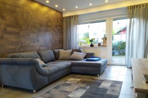 a living room with a couch and a large window at Appartement In Medenscheid Mit Garten Und Terrasse in Bacharach +11 photos