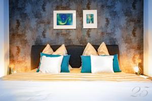 ein Schlafzimmer mit einem Bett mit blauen und weißen Kissen in der Unterkunft Komfortables Appartement in Bad Kötzting mit Eintritt in die Bade- und Saunawelt in Bad Koetzting