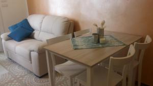 a living room with a table and a white couch at Casa Barnaba in Siracusa