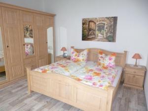 - une chambre avec un lit en bois et des oreillers dans l'établissement Ferienwohnung Im Vierseitenhof, à Annaberg-Buchholz