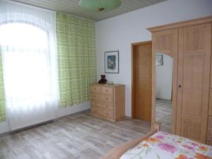 une chambre avec un lit, une commode et une fenêtre dans l'établissement Ferienwohnung Im Vierseitenhof, à Annaberg-Buchholz 6 autres photos