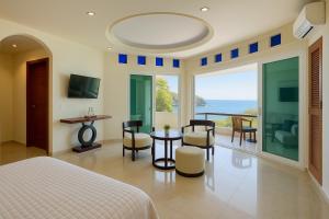 a bedroom with a bed and a table and chairs at Boca de Tomatlán Ocean Frontage Boutique Hotel in Puerto Vallarta