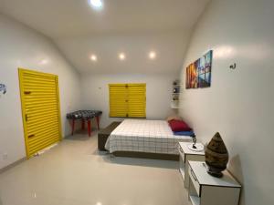 una camera con un letto e una porta gialla di Retiro Esperança a Santa Isabel do Pará