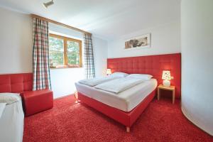 a red bedroom with a large bed and a window at Holiday Lodge Felix in Saalbach-Hinterglemm