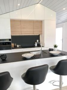 eine Küche mit schwarzen Stühlen und einer Küchentheke in der Unterkunft Ferienhaus in Rohrbach An Der Gölsen mit Garten, Grill und Terrasse in Rohrbach An Der Gölsen