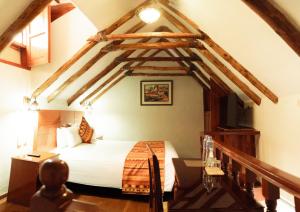 een slaapkamer met een bed in een kamer met houten balken bij Siete Ventanas in Cuzco