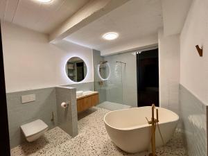 une salle de bain avec une baignoire, des toilettes et un lavabo dans l'établissement The Vintage Warehouse Loft, à Anvers