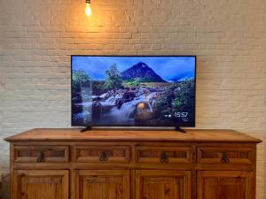 Elle comprend une télévision à écran plat installée au-dessus d'une commode en bois. dans l'établissement The Vintage Warehouse Loft, à Anvers