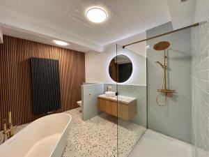 une salle de bain avec une baignoire, un lavabo et un miroir dans l'établissement The Vintage Warehouse Loft, à Anvers