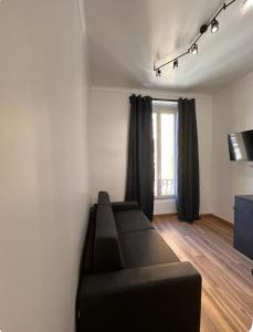 a living room with a black couch and a window at Jolie studio in Nice