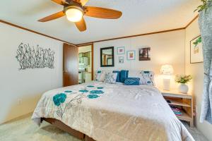 une chambre avec un lit avec un ventilateur de plafond dans l'établissement Walk to Houghton Lake! Family Retreat with Patio, à Houghton Lake