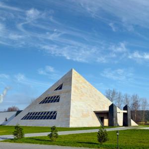 a pyramid shaped building with windows on a grass field at Hotel Nevada in Łagów