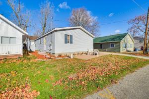 une maison blanche et une maison avec une cour dans l'établissement Walk to Houghton Lake! Family Retreat with Patio, à Houghton Lake