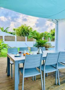 a table and chairs on a patio with an umbrella at Ile en Ile in Saint-François