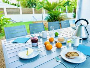 a blue table with plates of food and fruit on it at Ile en Ile in Saint-François
