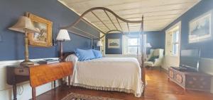 ein Schlafzimmer mit einem Bett mit blauen Wänden und einem Schreibtisch in der Unterkunft Old Orchard House in Brandon