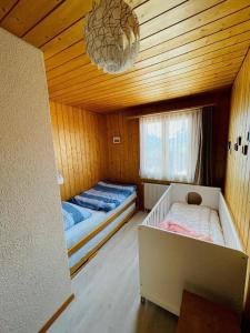 ein Schlafzimmer mit zwei Betten und einem Kronleuchter in der Unterkunft Chalet Hofer - 5-Bettwohnung in Hasliberg Wasserwendi