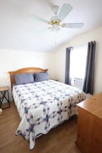 ein Schlafzimmer mit einem Bett mit Deckenventilator in der Unterkunft Cozy Cottage Alton Bay in Alton
