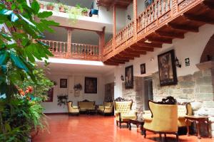 een grote woonkamer met stoelen en een trap bij Siete Ventanas in Cuzco