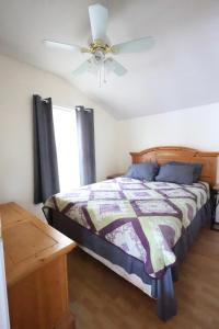 ein Schlafzimmer mit einem Bett und einem Deckenventilator in der Unterkunft Cozy Cottage Alton Bay in Alton