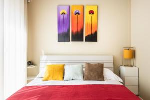 a bedroom with a bed with colorful paintings on the wall at Intera Struttura in Noto Marina +16 photos