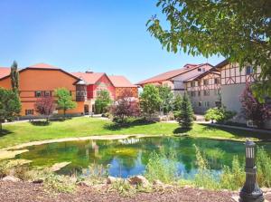 a building with a pond in the middle of a yard at Spacious King Suite in the Heart of Midway Near Park City & Sundance Ski Resorts - 209 in Mound City