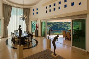 a dining room with a table with sculptures of women at Boca de Tomatlán Ocean Frontage Boutique Hotel in Puerto Vallarta