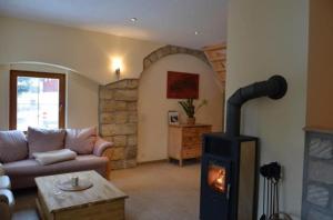 ein Wohnzimmer mit einem Holzofen in der Unterkunft Ferienhaus in Naundorf mit Grill und Terrasse - b53704 in Struppen