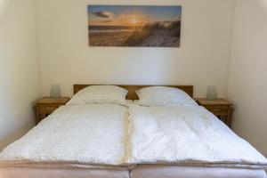ein Schlafzimmer mit 2 Betten und ein Bild von einem Strand in der Unterkunft Haus Aurora Lodge in Frielendorf