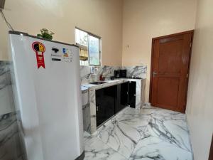 a kitchen with a marble floor and a refrigerator at Refúgio Marajoara in Soure