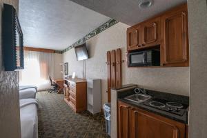 une chambre d'hôtel avec un lit et une cuisine avec un évier dans l'établissement Alpine Double Queen Suite Near Deer Valley & Park City - 231, à Mound City