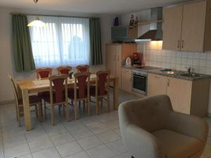 eine Küche mit Tisch und Stühlen und ein Esszimmer in der Unterkunft Ferienwohnung für 2 - 5 Personen mit zwei getrennten Schlafzimmern in Saas-Almagell