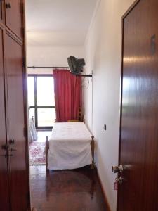 a small bedroom with a bed and a window at Residencial o Bras in Alvaiázere