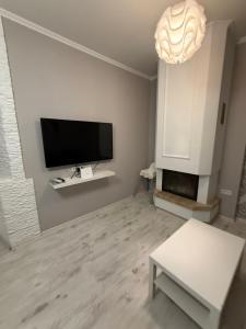 een woonkamer met een flatscreen-tv aan de muur bij Jurges Relax Graza in Daugavpils