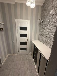 een badkamer met een aanrecht en een deur in een kamer bij Jurges Relax Graza in Daugavpils +2 foto's