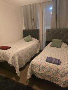 2 Betten in einem Hotelzimmer mit Röcken in der Unterkunft Acogedor y amplio Departamento A 5 min del centro in Rancagua