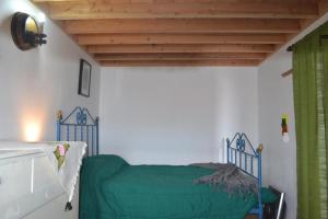 Schlafzimmer mit einem Bett mit grünem Laken in der Unterkunft Ferienhaus für 2 Personen ca 60 m in Feteira, Azoren Terceira in Angra do Heroísmo