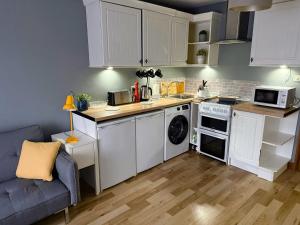 une cuisine avec des armoires blanches et un four à plaques de cuisson dans l'établissement Homely Stay Langley, à Langley Marish