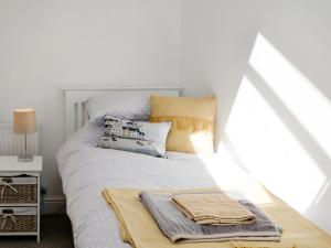 ein weißes Bett mit einem Haufen Handtücher drauf in der Unterkunft Loft 10 in Keswick