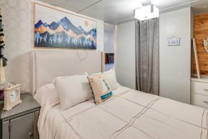 een slaapkamer met een wit bed en een schilderij aan de muur bij Lake Malone Cabin Getaway! Dock, Fire Pit, Grill in Dunmor