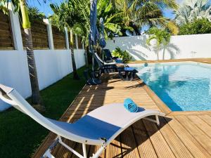 a deck with a swing and a swimming pool at Ile en Ile in Saint-François