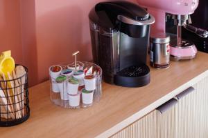 a counter with a coffee maker and cups on it at The Muse Hotel in Palm Springs