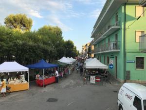 une rue avec un marché avec des tentes et des personnes se promenant dans l'établissement Ferienwohnung In Cupra Marittima, à Cupra Marittima