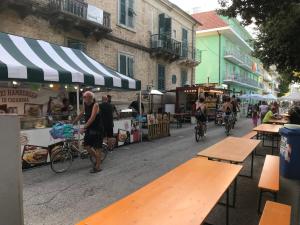 Un homme à vélo dans une rue avec des tables dans l'établissement Ferienwohnung In Cupra Marittima, à Cupra Marittima