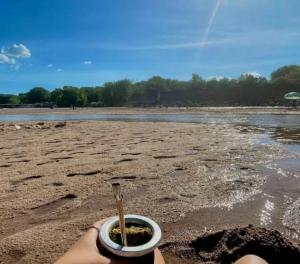 a person holding a cup with a spoon in it on the beach at Cabañas del IntiCo in Arroyo de Los Patos