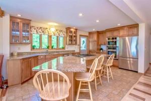 a kitchen with a large island with bar chairs at The Tinker Bell on Ossipee Lake in Ossipee +22 photos
