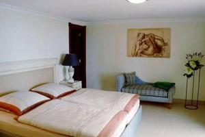 a bedroom with a large bed and a chair at Marbella Guia Isora in Guía de Isora