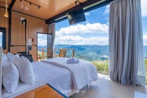 Un dormitorio con una cama blanca y una ventana grande. en Cabaña con chimenea e hidromasaje! VST044, en Annitapolis